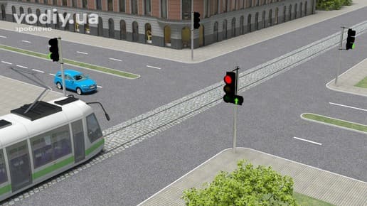 Проїзд регульованого перехрестя трамваєм та автомобілем, червоний сигнал світлофора з увімкненою зеленою стрілкою в додатковій секції
