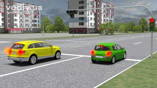 Зелений та жовтий автомобілі перед світлофором з червоним сигналом, горизонтальна дорожня розмітка 1.12 (стоп-лінія) на проїзній частині.