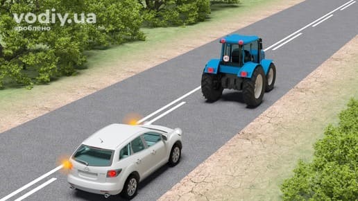 Горизонтальна дорожня розмітка 1.11, білий автомобіль з увімкненим лівим покажчиком повороту та синій трактор на дорозі поза населеним пунктом.