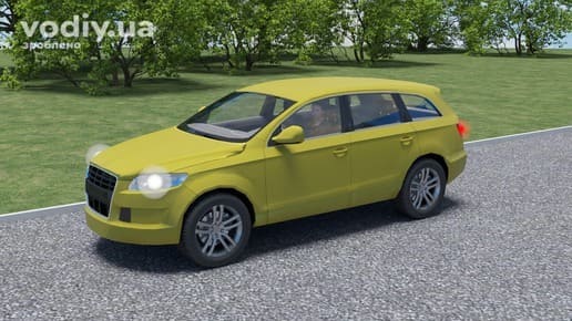 Жовтий легковий автомобіль категорії В на дорозі біля узбіччя, водій за кермом транспортного засобу.