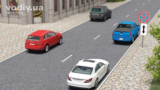 Дорожні знаки 3.34 «Зупинку заборонено», 7.2.4 «Зона дії». Чотири автомобілі на стоянці по обидва боки дороги в населеному пункті.