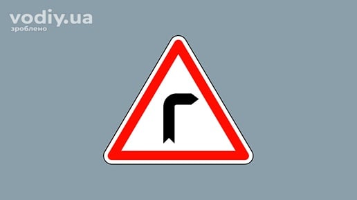 Дорожній знак 1.1 «Небезпечний поворот праворуч» на сірому фоні.