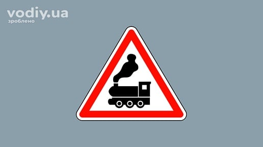 Дорожній знак 1.28 «Залізничний переїзд без шлагбаума» на сірому фоні. Попередження про наближення до переїзду через залізничні колії.