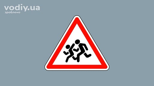 Попереджувальний дорожній знак 1.33 «Діти» на сірому фоні. Позначає ділянку дороги поблизу дитячих закладів, де можлива поява дітей на проїзній частині.