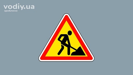 Дорожній знак 1.37 «Дорожні роботи» на жовтому фоні, попередження про ремонтні роботи на дорозі.
