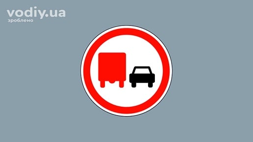 Дорожній знак 3.27 «Обгін вантажним автомобілям заборонено» на сірому фоні.