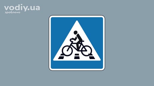 Дорожній знак 5.92.1 «Велосипедний переїзд» на синьому фоні для позначення місця перетину дороги велосипедистами.