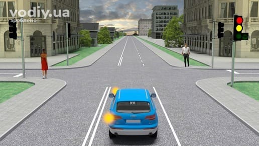 Синій автомобіль перед перехрестям, на світлофорі одночасно горять червоний і жовтий сигнали, пішоходи на тротуарі біля дороги.