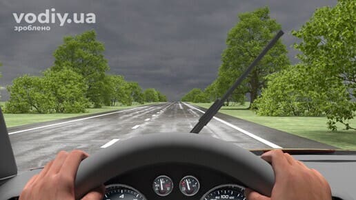 Несправний склоочисник автомобіля під час дощу, вид з місця водія на мокру дорогу та хмарне небо