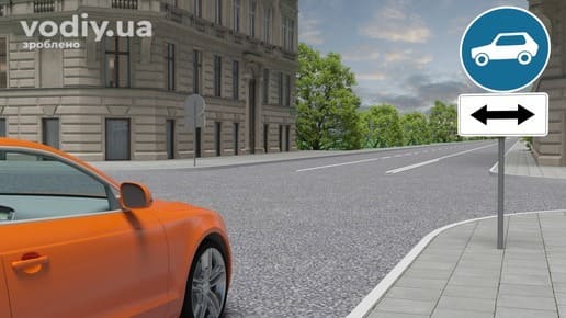 Дорожні знаки 4.11 «Рух легкових автомобілів», 7.3.3 «Напрямок дії». Помаранчевий автомобіль перед перехрестям у місті.