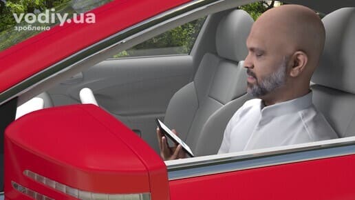 Водій тримає смартфон у руці під час руху автомобіля для використання навігації GPS