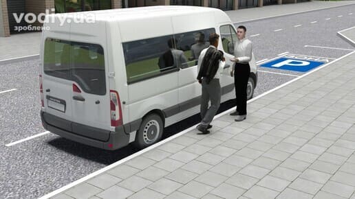 Білий мікроавтобус на узбіччі біля тротуару та двоє чоловіків, що спілкуються поруч із транспортним засобом.