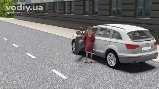 Жінка відчиняє двері білого автомобіля біля краю проїзної частини, погане самопочуття водія перед поїздкою.