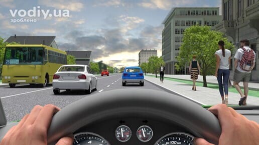 Руки водія на кермі автомобіля, рух вулицею міста, автобус та легкові авто попереду, пішоходи на тротуарі праворуч.