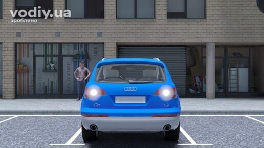 Синіий автомобіль на парковці з увімкненими білими ліхтарями заднього ходу, людина стоїть поруч на тротуарі.