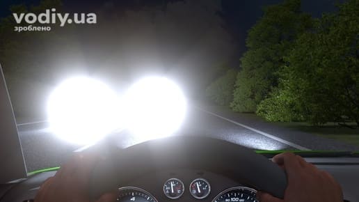 Засліплення водія дальнім світлом фар зустрічного автомобіля вночі, руки на кермі та вид на дорогу через лобове скло.