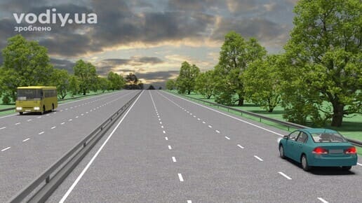 Дорога з чотирма смугами руху, розділювальною смугою та металевим огородженням, жовтий автобус та легковий автомобіль на проїзній частині.