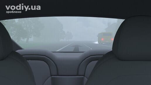 Вигляд через заднє скло автомобіля на дорогу в тумані, автобус попереду в умовах недостатньої видимості.