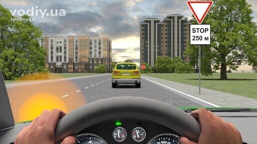 Зелений автомобіль готується до обгону жовтого авто, дорожні знаки: 2.1 «Дати дорогу», 7.1.2 «Відстань до об’єкта» перед перехрестям.