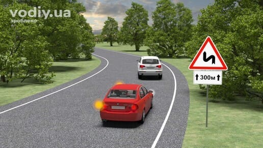 Червоний автомобіль з увімкненим лівим покажчиком повороту позаду білого авто, дорожні знаки: 1.3.1 «Декілька поворотів», 7.2.1 «Зона дії».