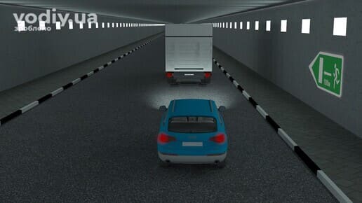Легковий автомобіль та вантажівка в тунелі, дорожній знак 5.79.1 «Аварійний вихід», обгін у тунелі.