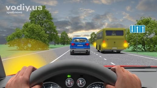 Червоний автомобіль, синій кросовер та автобус на дорозі, дорожній знак 5.17.1 «Напрямок руху по смугах», увімкнений лівий покажчик повороту.