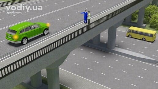 Зелений автомобіль з увімкненим правим покажчиком повороту на шляхопроводі, пішоходи на тротуарі мосту та жовтий автобус на дорозі під ним.