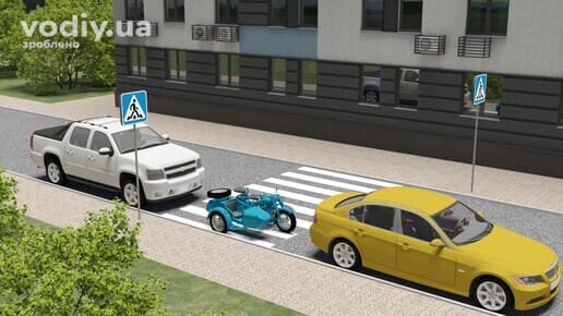 Дорожні знаки: 5.38.1, 5.38.2 «Пішохідний перехід», білий пікап, блакитний мотоцикл з коляскою та жовтий седан зупинилися біля розмітки 1.14.1 «зебра».