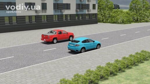 Червоний пікап та блакитний автомобіль стоять один навпроти одного на дорозі в населеному пункті, переривчаста розмітка 1.5.