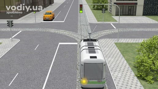 Трамвай з увімкненим покажчиком повороту та жовтий автомобіль на регульованому перехресті, зелений сигнал світлофора.