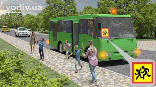 Зелений автобус із розпізнавальним знаком Діти, увімкненою аварійною сигналізацією та оранжевим маячком під час посадки дітей.