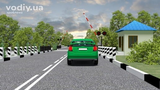Зелений автомобіль перед залізничним переїздом, відкритий шлагбаум, світлофор, будка чергового та дорожня розмітка 1.1, 1.12.