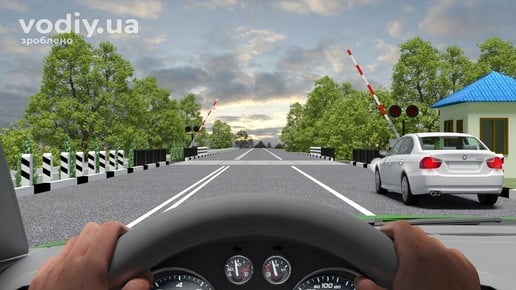 Рух через залізничний переїзд у два ряди, горизонтальна дорожня розмітка 1.1 та 1.3, відкритий шлагбаум перед коліями.